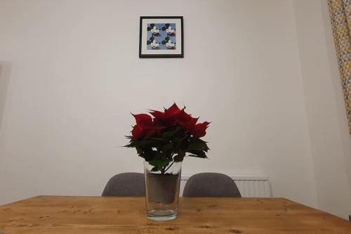 a vase with a red flower sitting on a table at Charming flat near Shoreditch in London