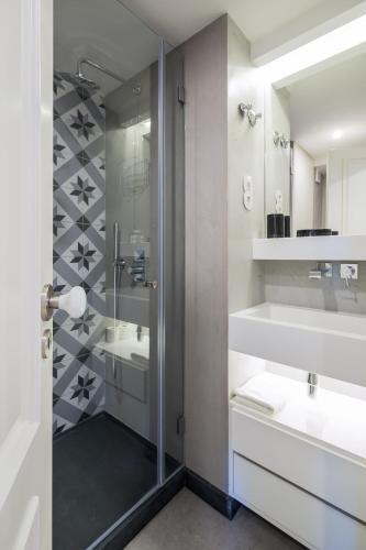 a bathroom with a shower and a sink and a mirror at Nomad's Augusta Collection Lisbon in Lisbon