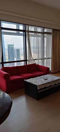 a living room with a red couch and a large window at Ts service suites at Times Square in Kuala Lumpur