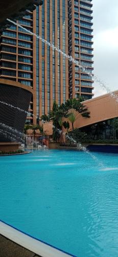a large pool of blue water in front of buildings at Ts service suites at Times Square in Kuala Lumpur