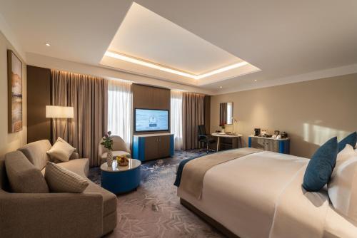 een hotelkamer met een bed, een bank en een stoel bij Braira Al Ahsa in Al Ahsa