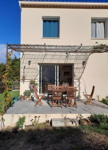 une terrasse avec une table et des chaises devant une maison dans l'établissement Chambre privée, à Tulette
