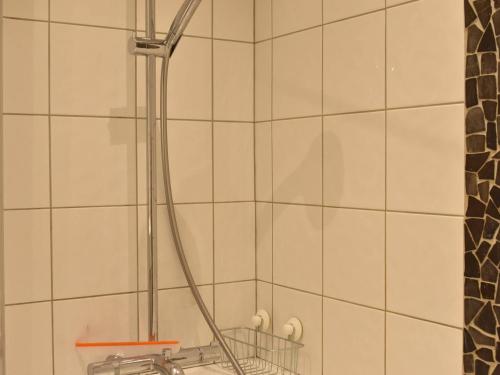 un bagno con soffione doccia e piastrelle bianche di Appartement Méribel, 1 pièce, 4 personnes - FR-1-180-206 a Méribel