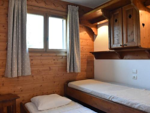 a bedroom with two beds in a log cabin at Appartement Méribel, 3 pièces, 6 personnes - FR-1-180-201 in Méribel