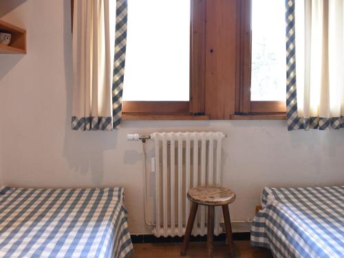 a room with two beds and a stool and a window at Appartement Méribel, 2 pièces, 4 personnes - FR-1-180-207 in Méribel