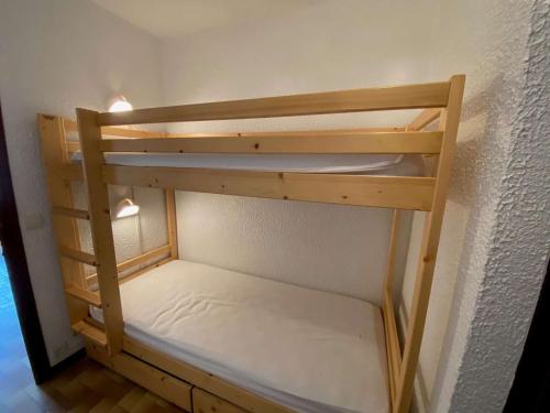 un lit superposé en bois dans une petite pièce dans l'établissement Studio skis aux pieds avec balcon au Grand-Bornand - FR-1-241-20, au Grand-Bornand