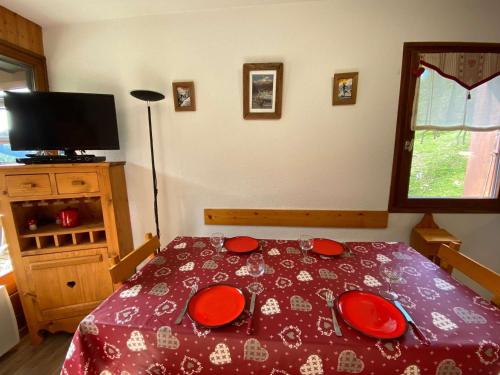 a bedroom with a bed with red plates on it at Appartement Le Grand-Bornand, 2 pièces, 6 personnes - FR-1-241-52 in Le Grand-Bornand