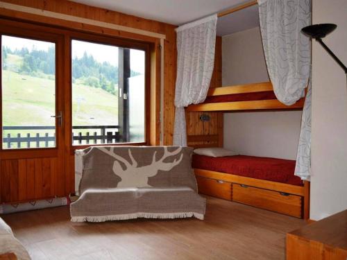 a bedroom with a bunk bed and a chair and a window at Appartement Le Grand-Bornand, 1 pièce, 4 personnes - FR-1-241-116 in Le Grand-Bornand