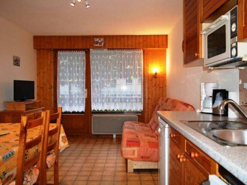 Il comprend une cuisine avec un évier et une table. dans l'établissement Appartement 2 pièces cabine, 300m pistes/comm, mén. inclus, parking - FR-1-241-11, au Grand-Bornand