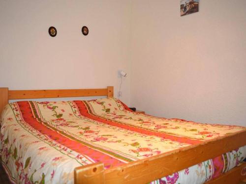 a bed in a bedroom with a bedspread on it at Appartement Le Grand-Bornand, 2 pièces, 6 personnes - FR-1-241-11 in Le Grand-Bornand