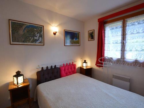 a bedroom with a red bed and a window at Appartement Le Grand-Bornand, 2 pièces, 6 personnes - FR-1-241-17 in Le Grand-Bornand