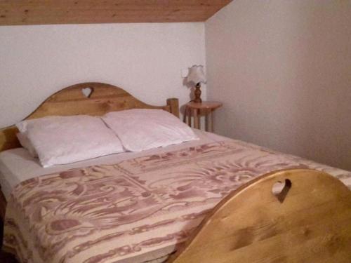 łóżko z drewnianym zagłówkiem w sypialni w obiekcie Appartement Le Grand-Bornand, 2 pièces, 6 personnes - FR-1-241-21 w mieście Le Grand-Bornand