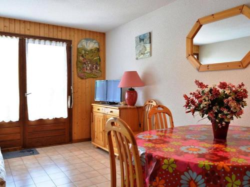 une salle à manger avec une table et une télévision dans l'établissement Appart. cosy 2 pièces, 6 pers, terrasse, garage, proche pistes - Le Grand-Bornand - FR-1-241-25, au Grand-Bornand