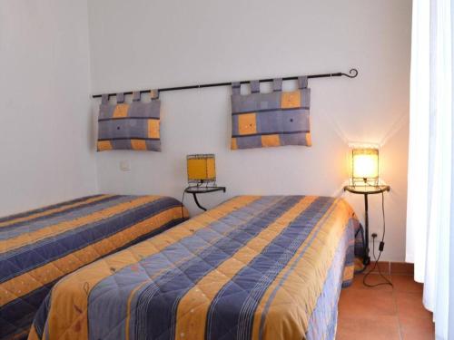 - 2 lits dans une chambre d'hôtel avec 2 lampes dans l'établissement Appartement 3 pièces avec terrasse, piscine, parking et navette plage à Sainte-Maxime - FR-1-226-189, à Sainte-Maxime