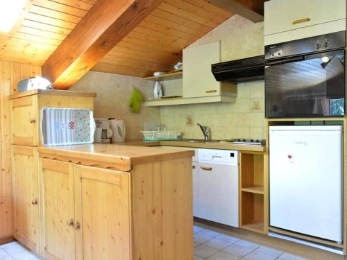 a kitchen with white appliances and wooden cabinets at Appartement Le Grand-Bornand, 2 pièces, 6 personnes - FR-1-241-94 in Le Grand-Bornand