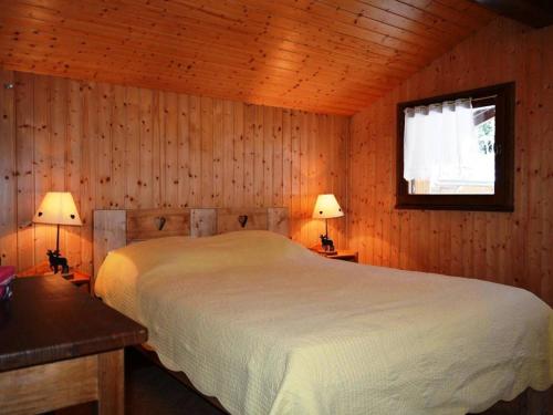 a bedroom with a bed and a window and two lamps at Appartement Le Grand-Bornand, 2 pièces, 6 personnes - FR-1-241-94 in Le Grand-Bornand