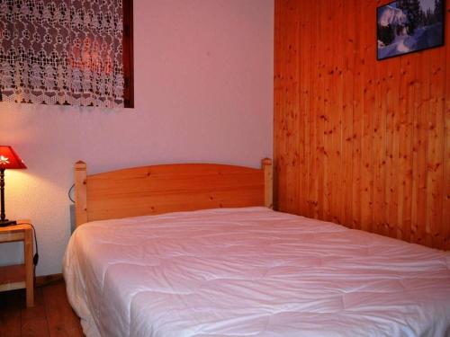 ein Schlafzimmer mit einem Bett mit einem Kopfteil aus Holz in der Unterkunft Studio Le Grand-Bornand, 1 pièce, 4 personnes - FR-1-241-109 in Le Grand-Bornand