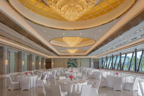 a banquet hall with white tables and white chairs at Hyatt Regency Trivandrum in Trivandrum
