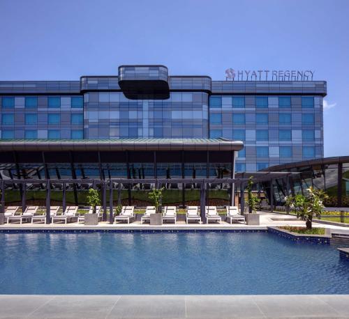 a hotel with a swimming pool in front of a building at Hyatt Regency Trivandrum in Trivandrum