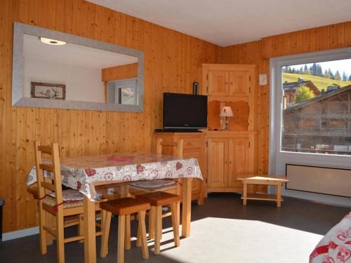 a dining room with a table and chairs and a television at Appartement Le Grand-Bornand, 1 pièce, 4 personnes - FR-1-241-129 in Le Grand-Bornand