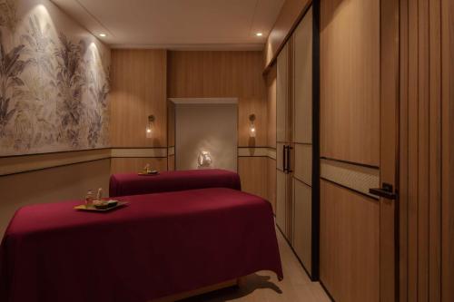two beds in a hotel room with red sheets at Hyatt Regency Trivandrum in Trivandrum