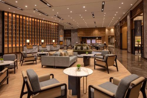a hotel lobby with couches and tables and chairs at Hyatt Regency Trivandrum in Trivandrum