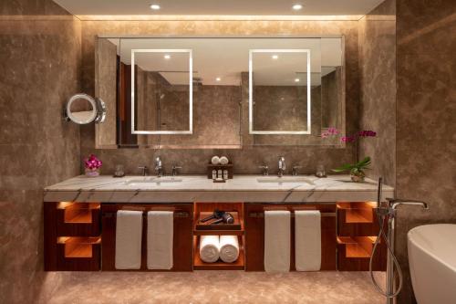 a bathroom with two sinks and a large mirror at Hyatt Regency Trivandrum in Trivandrum