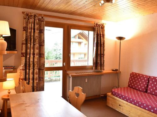 a living room with a red couch and a window at Appartement Méribel, 1 pièce, 4 personnes - FR-1-180-297 in Méribel