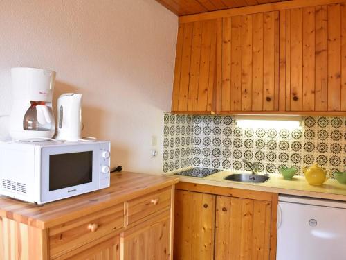 une cuisine avec un micro-ondes et un évier dans l'établissement Studio 2/4 pers, Accès Pistes et Piscine, Proche Commerces, Méribel - FR-1-180-297, à Méribel