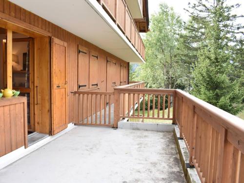 un porche d'une maison avec une clôture en bois et des arbres dans l'établissement Studio 2/4 pers, Accès Pistes et Piscine, Proche Commerces, Méribel - FR-1-180-297, à Méribel