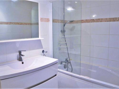 une salle de bain blanche avec une douche et un lavabo dans l'établissement Appartement 3 pièces avec piscine et garage, proche plage - FR-1-251-6, à Bormes-les-Mimosas