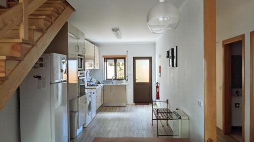 cocina con electrodomésticos blancos y suelo de madera en Casa Domingues Guest House, en Caldas da Rainha