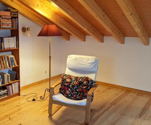 una silla blanca sentada en una habitación con lámpara en Casa Domingues Guest House, en Caldas da Rainha