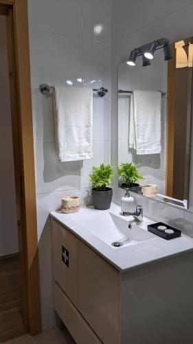 a bathroom with a sink and a mirror at Casa Domingues Guest House in Caldas da Rainha