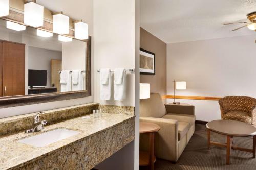 uma casa de banho do hotel com um lavatório e uma sala de estar em AmericInn by Wyndham Baudette em Baudette