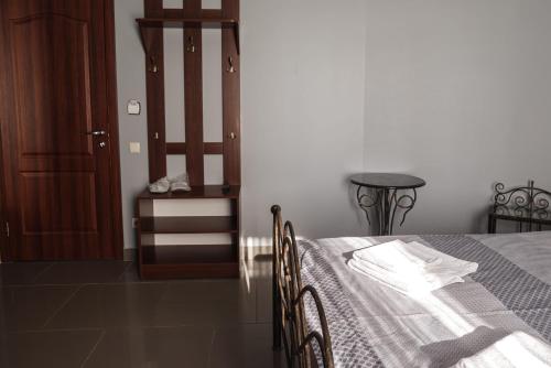 a bedroom with a bed and a table and a door at Ermitazh Hotel Complex in Novomoskovsʼk