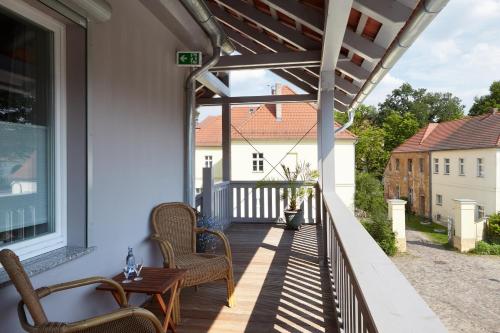 une terrasse couverte avec des chaises et une table sur une maison dans l'établissement Pension Schlossgasse, à Lieberose