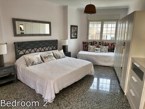 een slaapkamer met 2 bedden en een spiegel bij Lge 4 bed villa own pool 90 mts beach sea views in Roquetas de Mar