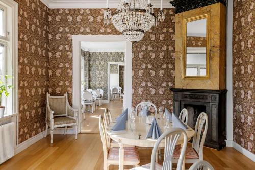 a dining room with a table and chairs and a fireplace at Sure Hotel by Best Western Ojaby Herrgard in Växjö