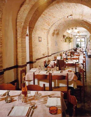 a row of tables in a restaurant with white table cloth at Pensione Delfino Azzurro in Loreto
