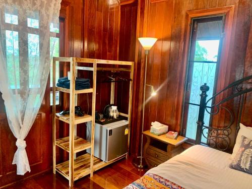 a bedroom with a bed and a wooden wall at Rang Robin Farmstay with swimming pool in Ban Wang Muang