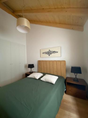 1 dormitorio con 1 cama verde y 2 lámparas en THE ORANGE TREE HOUSES - vista Pátio by Live and Stay, en Abrantes