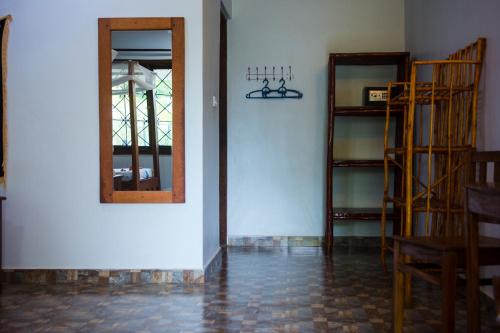 a room with a mirror and some wooden shelves at Highland Bungalows in Nungwi