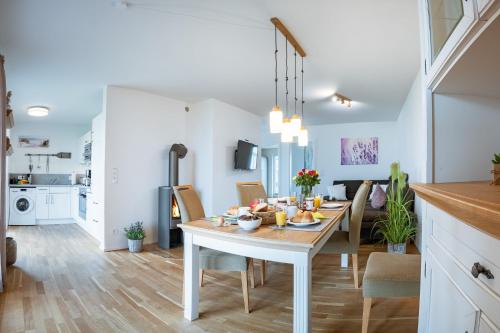 a kitchen and dining room with a table and chairs at Fewo MEERwert by Seeblick Ferien ORO, Familienfreundlich, Sauna, Kamin,XL Dusche in Olpenitz
