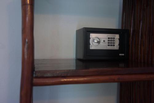 a microwave sitting on top of a wooden shelf at Highland Bungalows in Nungwi