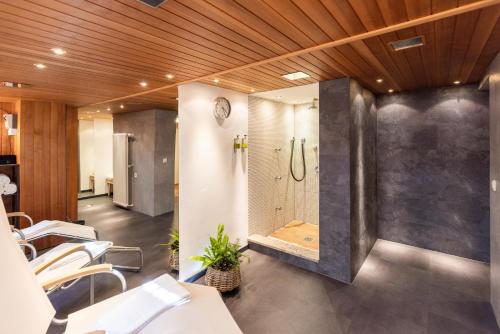 a bathroom with a walk in shower and a walk in shower at Hubertus Apartments in Schliersee