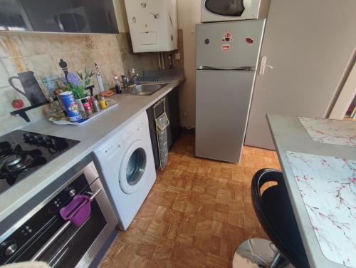une cuisine avec un réfrigérateur et une machine à laver dans l'établissement Studio en RDC avec terrasse, à Nevers