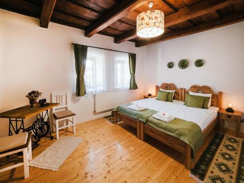 a bedroom with a bed and a table and a window at A MI KISHÁZUNK vendégház in Szomód