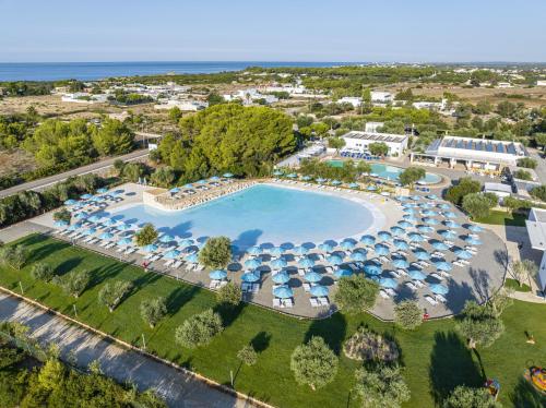 vista aerea su una piscina del resort con ombrelloni di PORTO CESAREO CAMPING & Village a Porto Cesareo