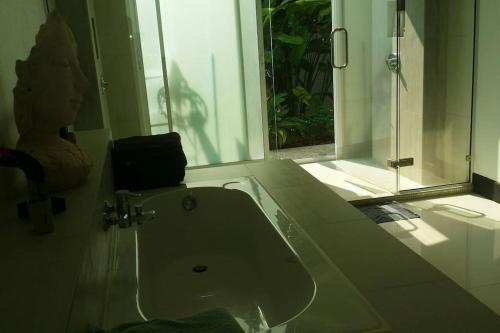 y baño con lavabo y ducha acristalada. en The Terrace, spacious 3 bedroom luxury pool villa en Ko Chang